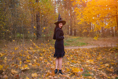 Full length of woman standing in forest