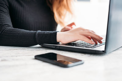 Close-up of person using laptop on table