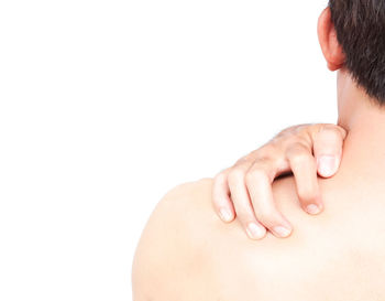 Rear view of person touching hand against white background