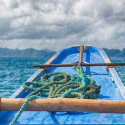 Close-up of rope tied on bollard against sky