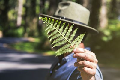 Earth day and love for nature concept with attractive man with a fern leaf on his face 