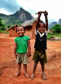 Siblings playing with arms raised