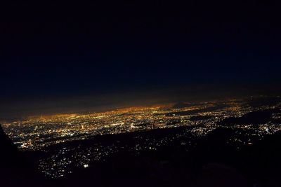 Aerial view of illuminated cityscape against sky at night