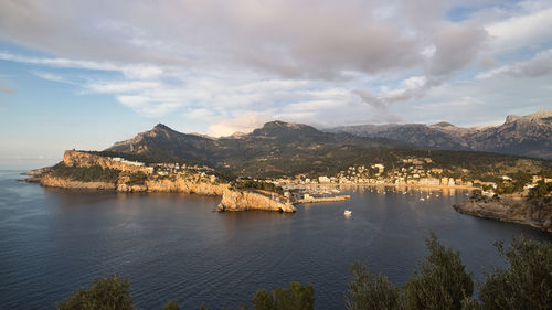 Scenic view of sea by mountains against sky