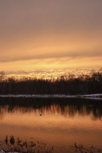 Scenic view of lake against orange sky