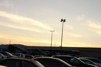 Cars on street against sky during sunset