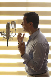 Close-up of mature man standing against wall