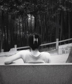 Rear view of woman sitting in water