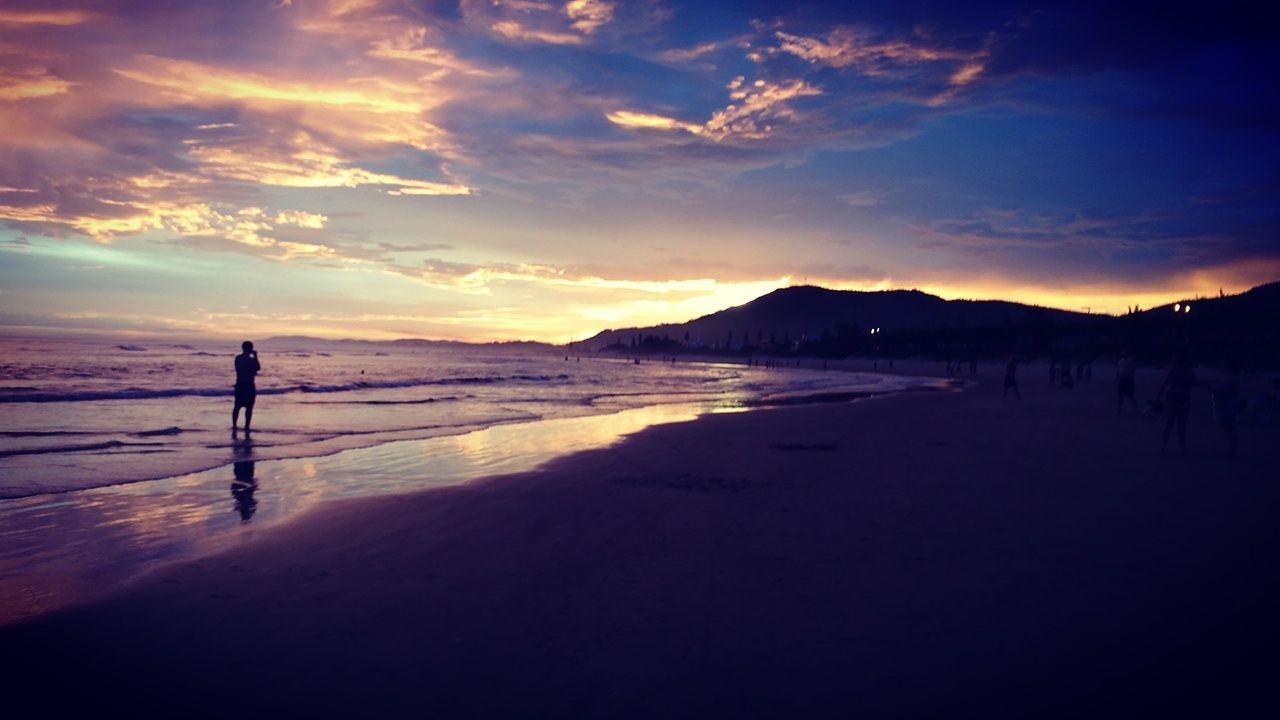 SILHOUETTE MAN WALKING AT BEACH AGAINST SKY DURING SUNSET