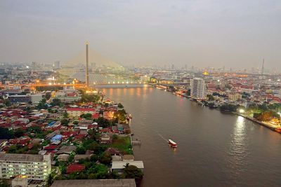 High angle view of bridge over river by buildings against sky