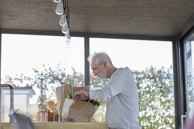 Side view of man sitting on table