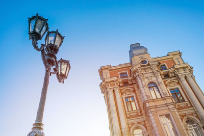 Street lamp and old house against blue sky and sunlight. bottom view.