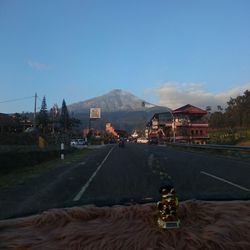 Vehicles on road against clear blue sky