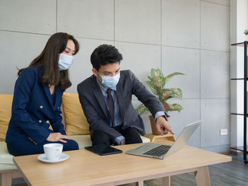 Young couple sitting on table at home