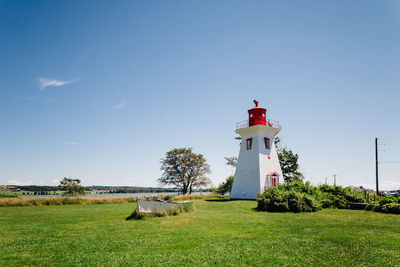 Scenic view of grassy field against blue sky