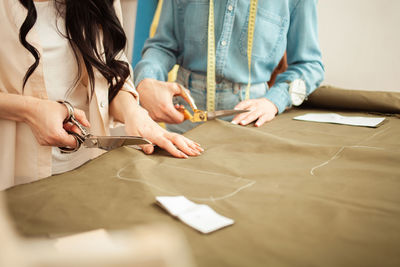 Midsection of business colleagues working on table