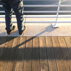 Low section of man standing on pier