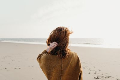 Rear view of woman standing on beach