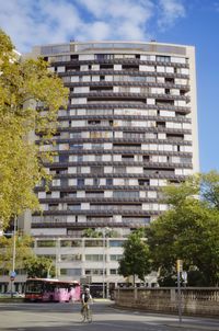 Building by street in city against sky