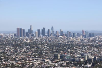 Aerial view of buildings in city against clear sky