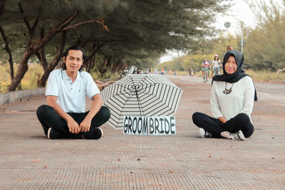 Portrait of smiling young couple sitting outdoors