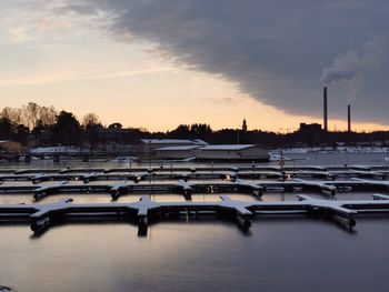 Boats in lake against sky at sunset