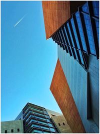 Low angle view of skyscraper against clear blue sky