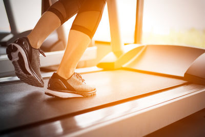 Low section of woman exercising on treadmill