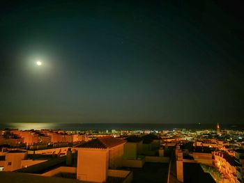 High angle view of illuminated buildings against sky at night