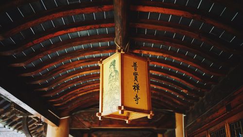 Low angle view of text hanging on ceiling at temple