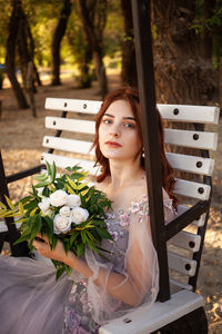 Beautiful bride with bouquet flowers stands on forest background. rustic style. 