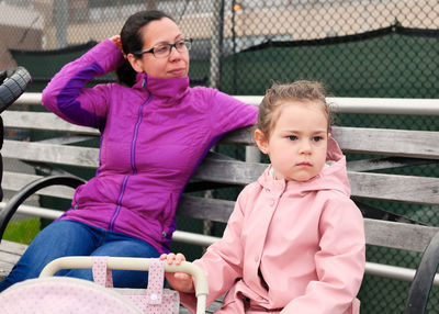 Mom and daughter enjoing a day on the boardwalk with baby strollers, toy and real