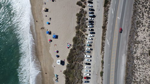 People enjoying the beach, while you can see the mountain, the sea, the beach and the road