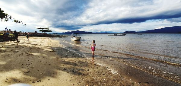 Woman on beach against sky