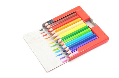 High angle view of multi colored pencils against white background