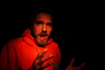 Portrait of surprised man with open mouth in darkroom