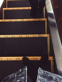 Low section of man standing on escalator
