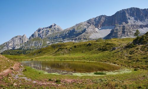 Scenic view of lake and mountains against clear sky