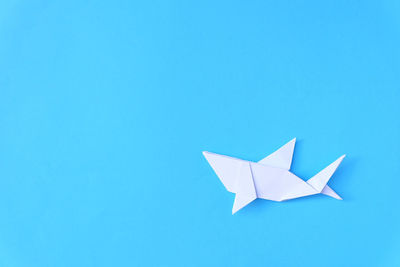 Directly above shot of paper fish over blue background