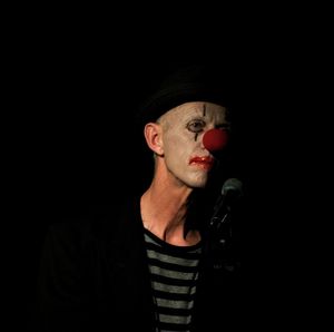 Portrait of young man wearing hat against black background