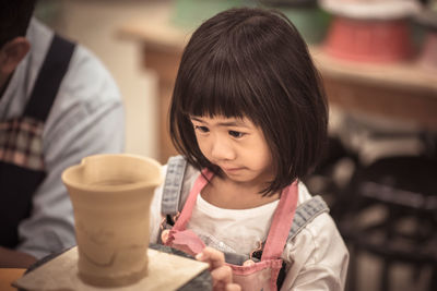 Close-up of a girl holding drink at table