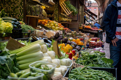 Midsection of man standing by vegetable market stall