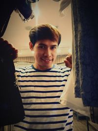 Portrait of young man standing at home