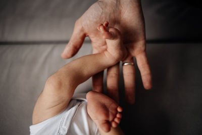 Father hold the leg of a newborn baby, trust and care