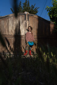 Portrait of woman standing against plants