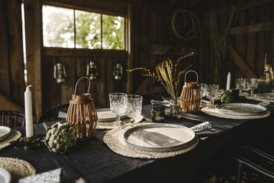 Plates and glasses arranged on dining table during social gathering