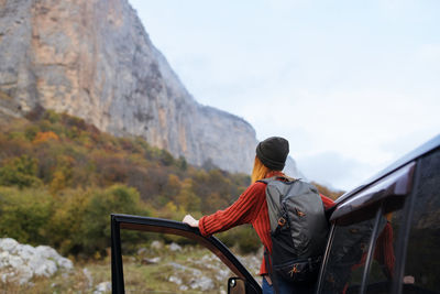 Rear view of man looking at mountain against sky