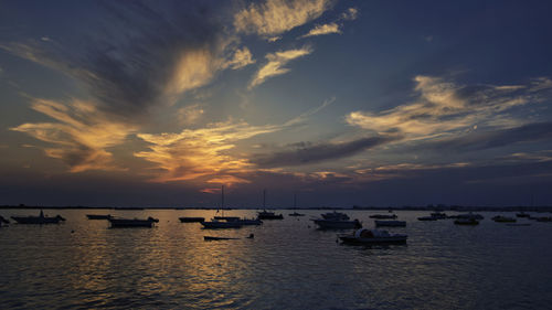 Boats in sea at sunset