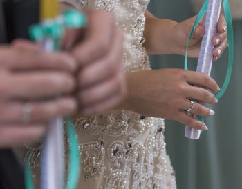 Midsection of females holding sticks