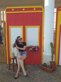 Full length of woman sitting on chair at entrance